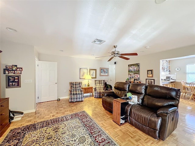 living room featuring light parquet floors, ceiling fan, and a textured ceiling