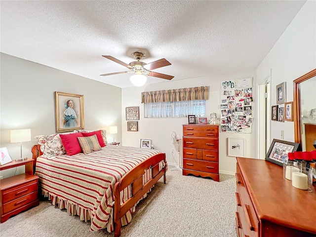 bedroom featuring ceiling fan, light colored carpet, and a textured ceiling