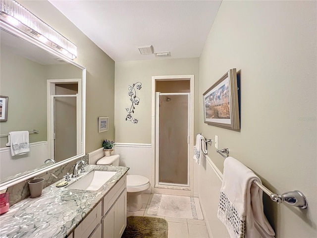 bathroom featuring tile patterned flooring, toilet, vanity, and walk in shower