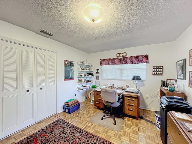 office space with a textured ceiling and light parquet flooring