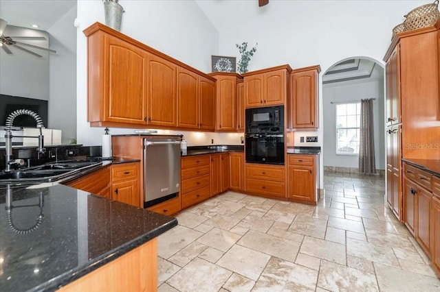 kitchen with arched walkways, a sink, ceiling fan, high vaulted ceiling, and black appliances