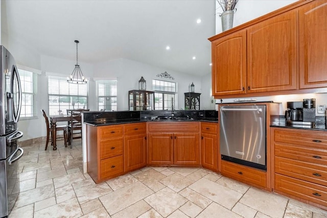 kitchen with stainless steel appliances, a peninsula, an inviting chandelier, and brown cabinets