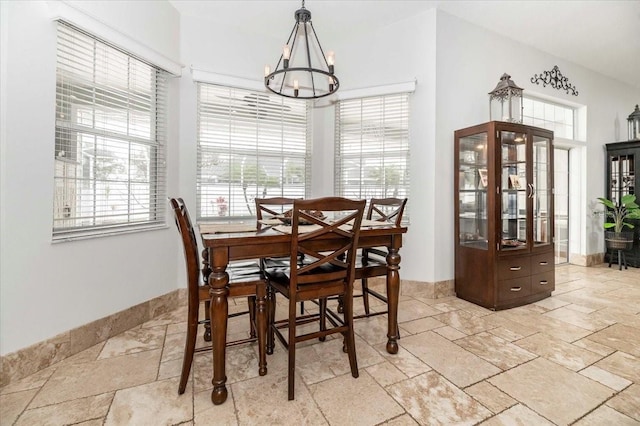 dining area featuring a chandelier and stone tile flooring