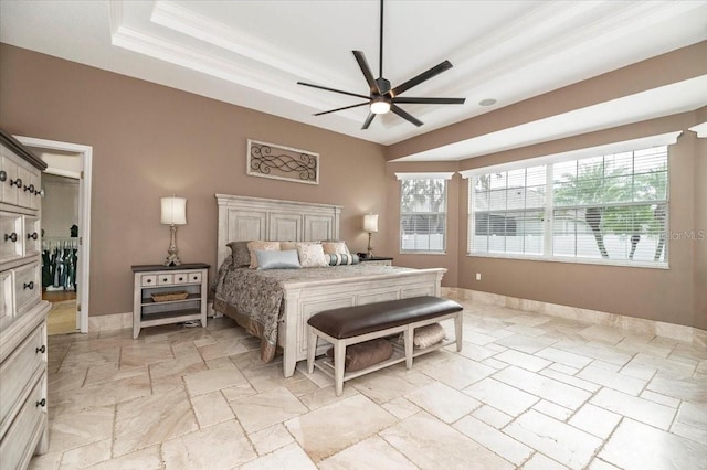 bedroom featuring baseboards, multiple windows, a raised ceiling, and stone tile floors