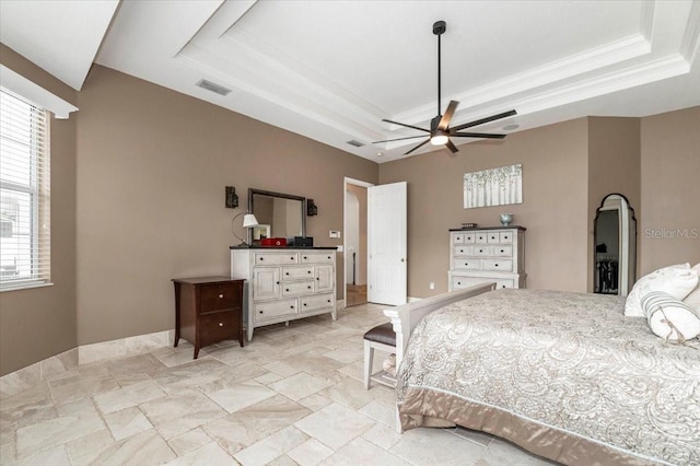 bedroom with ornamental molding, a raised ceiling, visible vents, and stone finish flooring