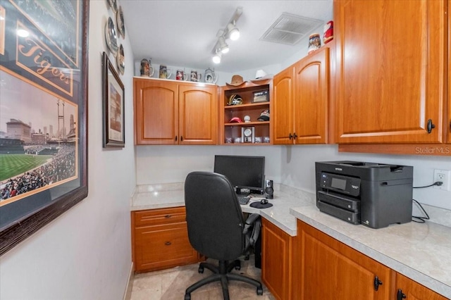 office area with built in desk, visible vents, and track lighting