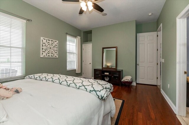 bedroom with wood finished floors, a ceiling fan, and baseboards