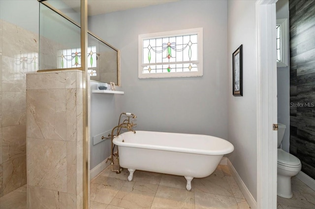 full bathroom featuring baseboards, toilet, marble finish floor, walk in shower, and a freestanding bath