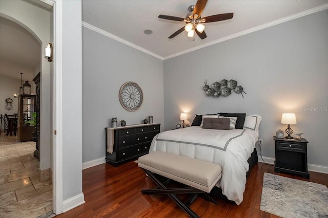 bedroom with arched walkways, ornamental molding, wood finished floors, and baseboards