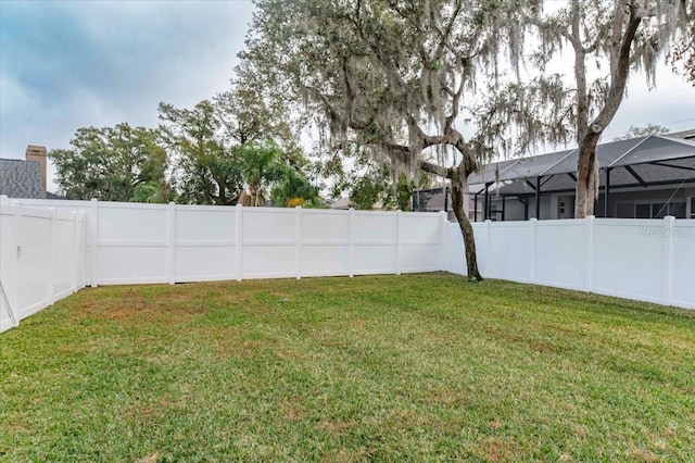 view of yard featuring a lanai and a fenced backyard