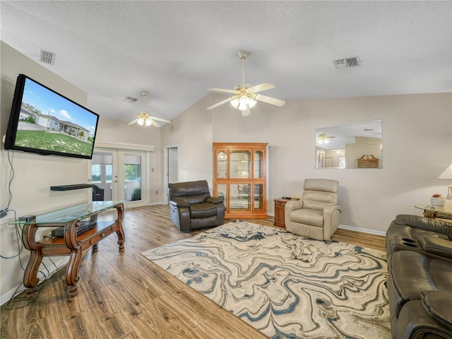 living room featuring hardwood / wood-style floors, a textured ceiling, and french doors