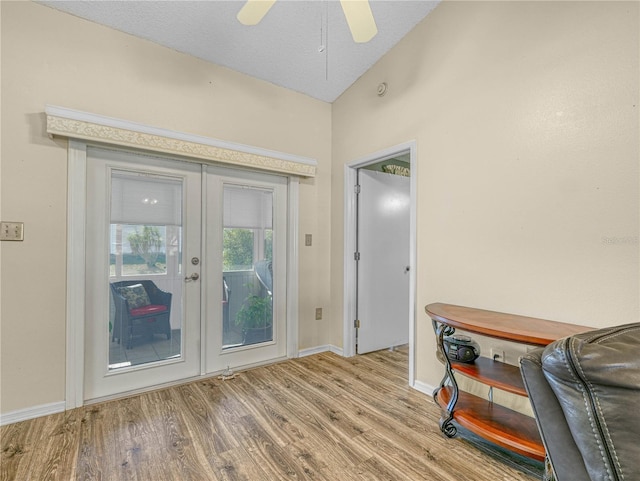 doorway with french doors, vaulted ceiling, a textured ceiling, light wood-type flooring, and ceiling fan