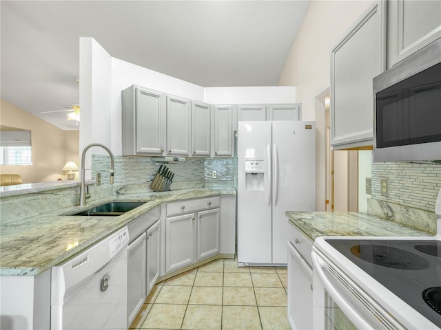 kitchen with sink, white appliances, light stone counters, tasteful backsplash, and light tile patterned flooring