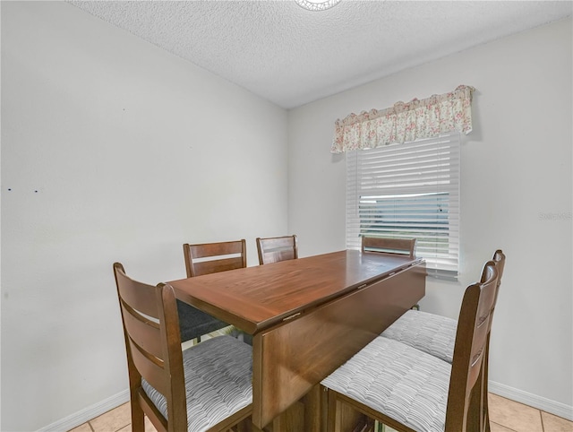 tiled dining area featuring a textured ceiling