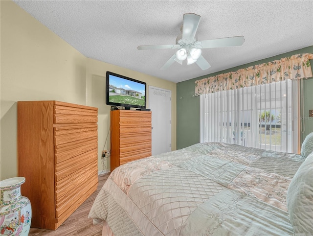 bedroom featuring hardwood / wood-style flooring, ceiling fan, and a textured ceiling