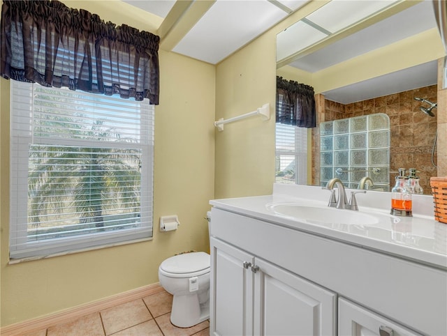 bathroom featuring tile patterned flooring, vanity, toilet, and a tile shower