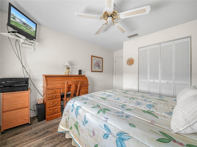 bedroom featuring ceiling fan, dark wood-type flooring, a textured ceiling, and a closet