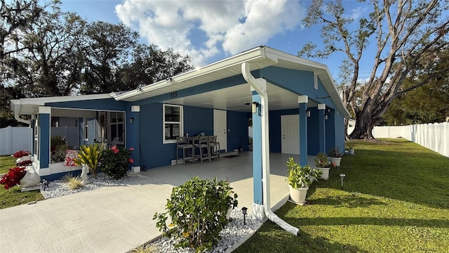 rear view of house featuring a carport and a yard