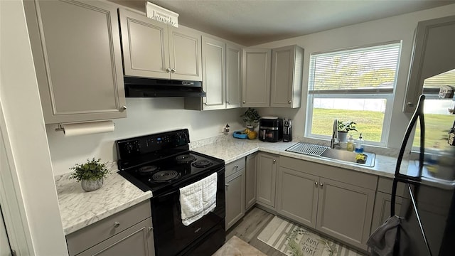 kitchen featuring sink, gray cabinets, electric range, light hardwood / wood-style floors, and light stone countertops