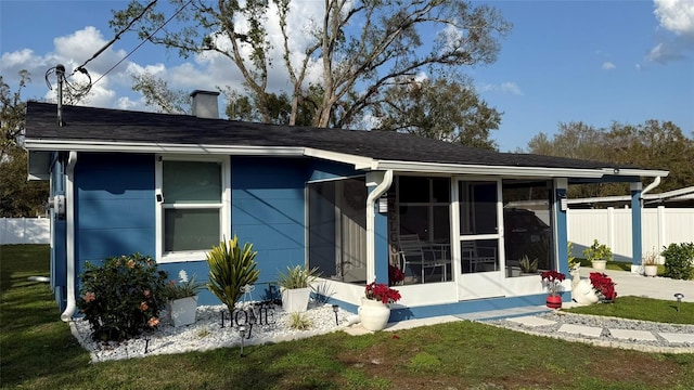 back of house featuring a yard and a sunroom