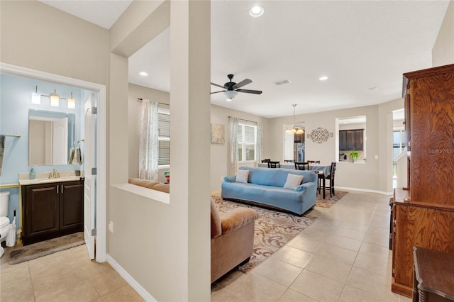 living room with sink, light tile patterned floors, and ceiling fan