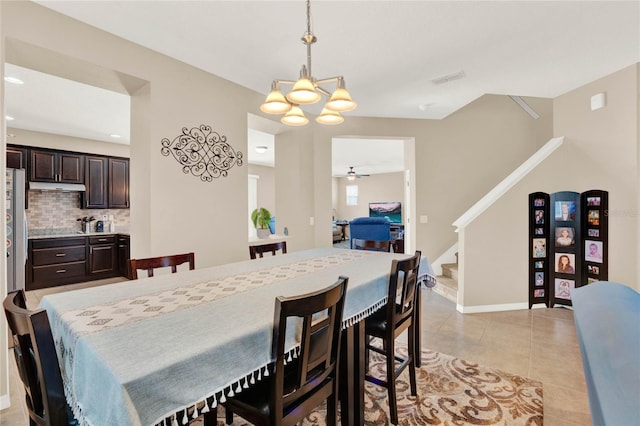 dining space featuring ceiling fan with notable chandelier and light tile patterned flooring