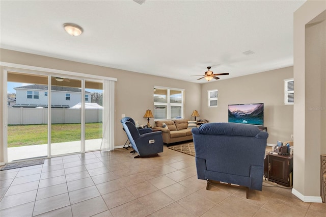 tiled living room with ceiling fan and a healthy amount of sunlight