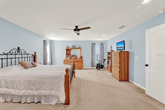 bedroom featuring light carpet, multiple windows, and ceiling fan