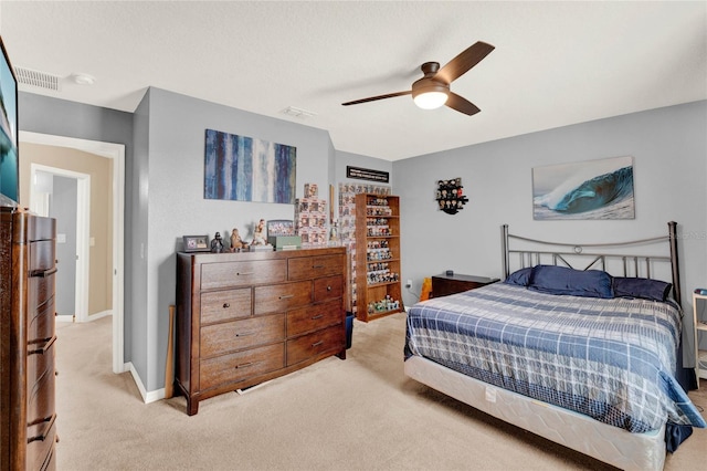 bedroom featuring ceiling fan, light colored carpet, and a textured ceiling