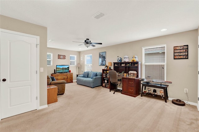 carpeted home office featuring ceiling fan