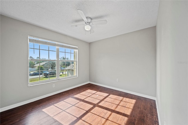 spare room featuring a textured ceiling, dark wood-type flooring, and ceiling fan