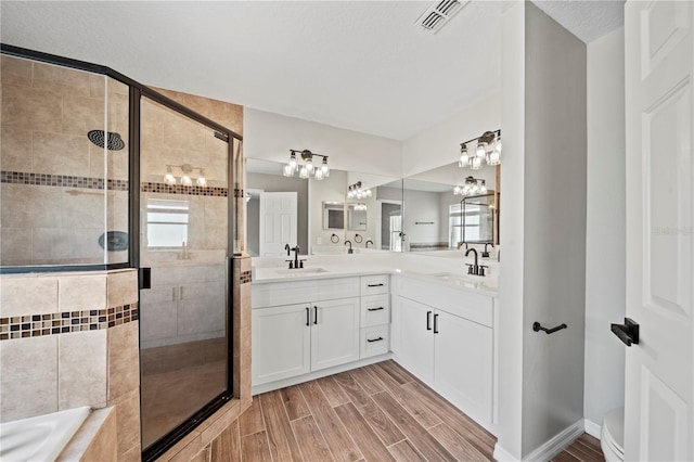 bathroom featuring vanity, plus walk in shower, and a textured ceiling