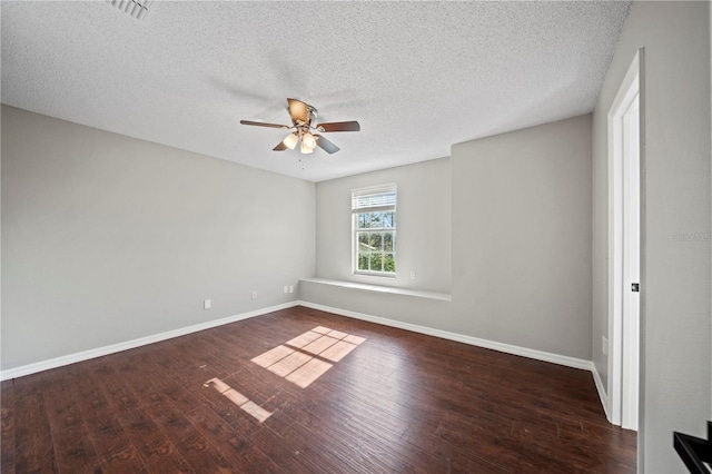 empty room featuring a textured ceiling, dark wood-type flooring, and ceiling fan