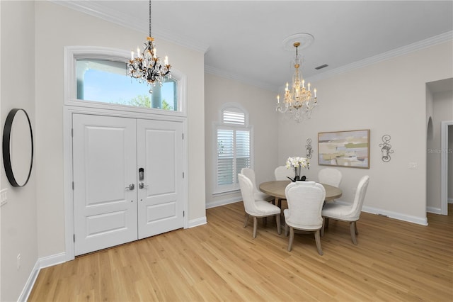 entrance foyer featuring ornamental molding, a chandelier, and light hardwood / wood-style floors