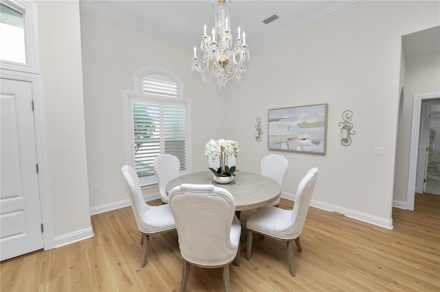 dining area with crown molding, a chandelier, and light wood-type flooring