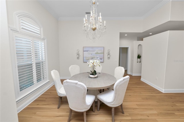 dining area featuring ornamental molding, a chandelier, and light hardwood / wood-style floors