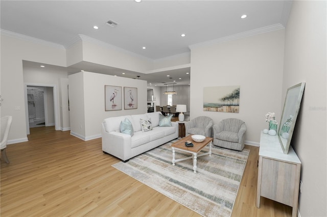 living room featuring crown molding and light hardwood / wood-style flooring