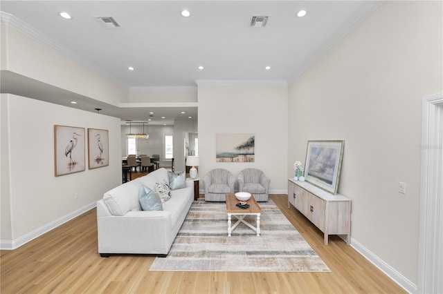 living room featuring crown molding and light hardwood / wood-style flooring