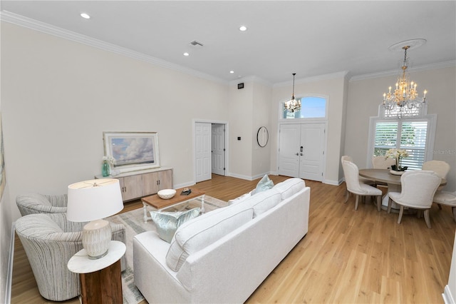 living room with crown molding, light hardwood / wood-style floors, and a notable chandelier