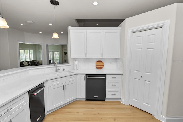 kitchen with decorative light fixtures, sink, white cabinets, backsplash, and light hardwood / wood-style flooring