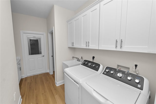 laundry area featuring cabinets, independent washer and dryer, light hardwood / wood-style floors, and sink