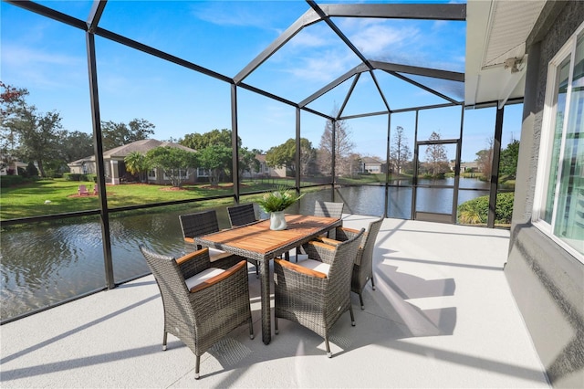 view of patio featuring a water view and glass enclosure