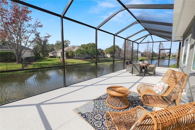 view of patio featuring a lanai and a water view