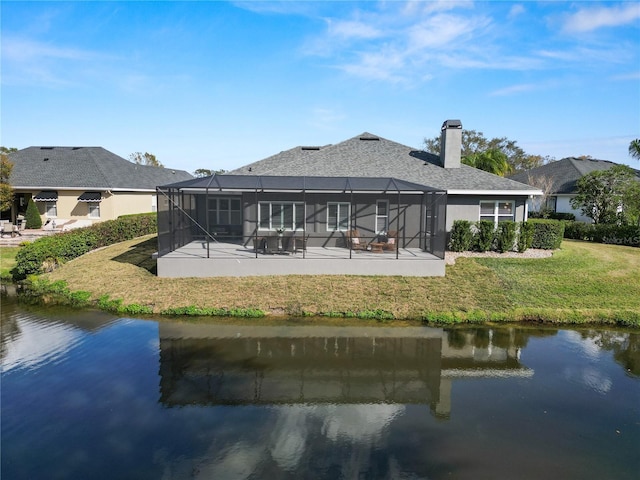 rear view of property with a yard, a lanai, a patio, and a water view