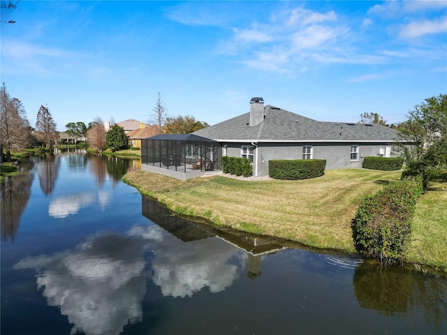 back of house featuring a water view, a yard, and glass enclosure