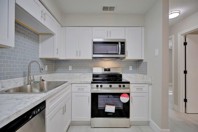 kitchen featuring stainless steel appliances, sink, and white cabinets