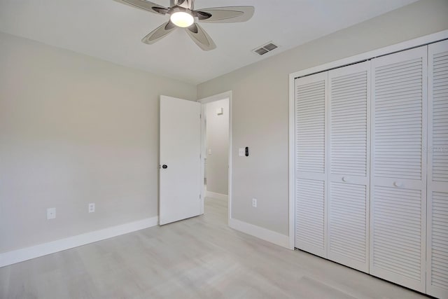 unfurnished bedroom featuring ceiling fan, light hardwood / wood-style floors, and a closet