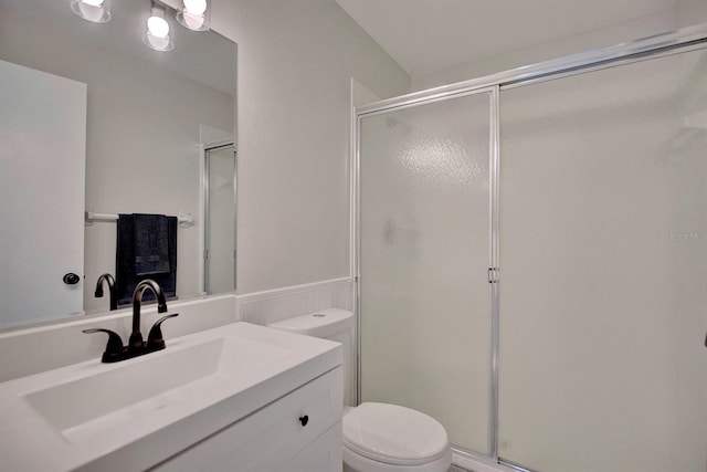 bathroom with vanity, toilet, and a shower with shower door