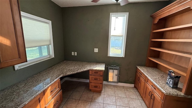 office with light tile patterned flooring, ceiling fan, and built in desk