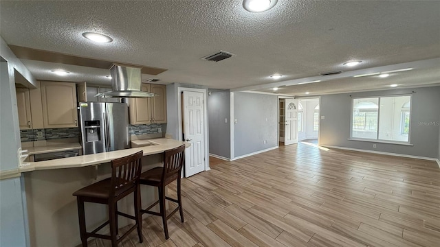 kitchen featuring extractor fan, light brown cabinetry, decorative backsplash, light hardwood / wood-style floors, and stainless steel refrigerator with ice dispenser